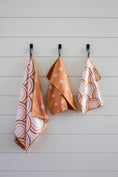 Load image into Gallery viewer, This is a picture of our 18"X30" microfiber dishtowel.  Hanging on a wall by its loop next to the matching washcloths for this towel.  The dishtowel features our pink rainbow pattern on one side with our orange-ish polka-dot pattern on the other side.  Each washcloth is 13"X13" and features one of the two-sides of the dishtowel. The matching dishtowels can be found in the washcloth collection and are called mini arches and mini dot to dot.
