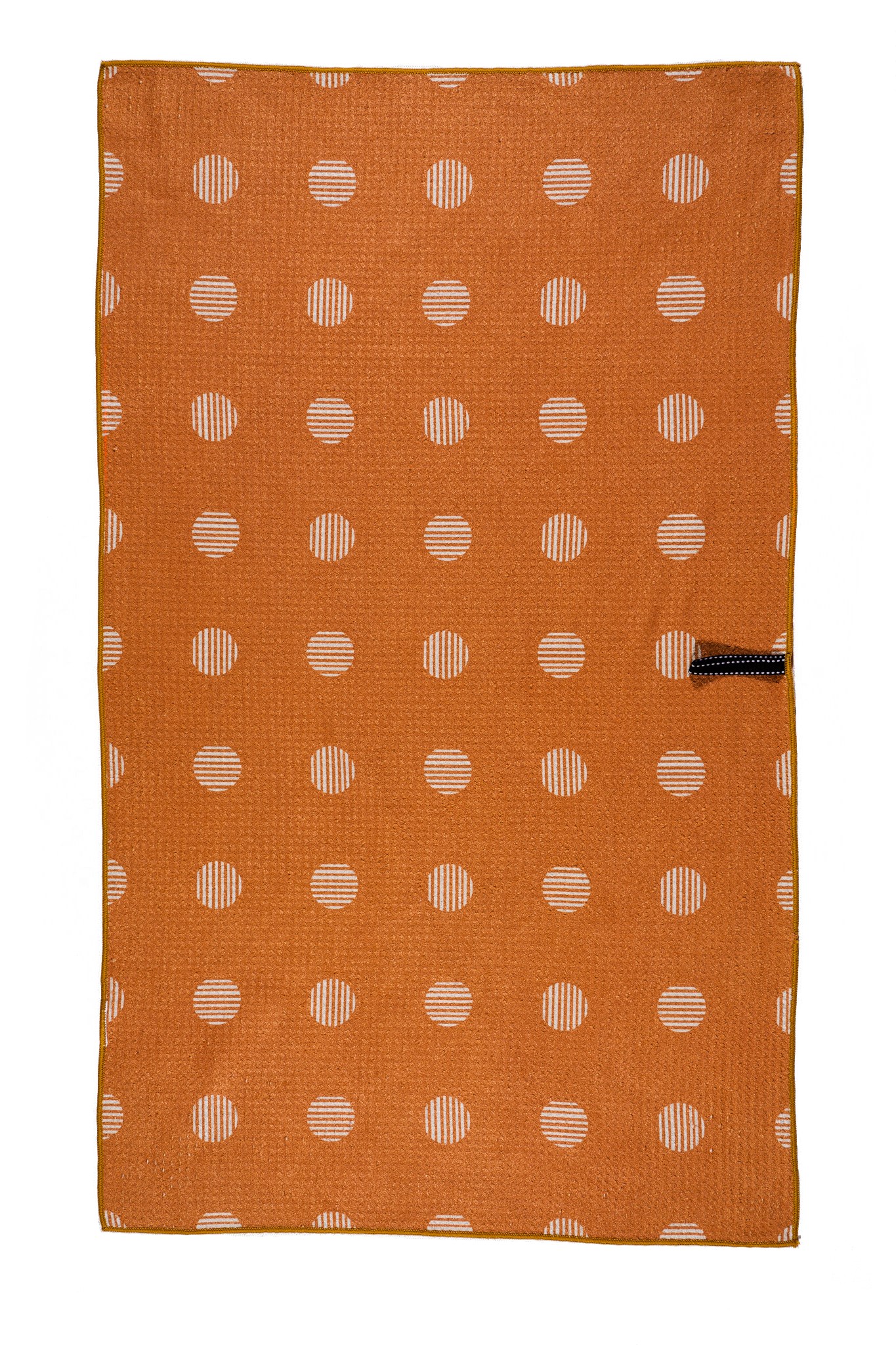 This picture is showing one side of the double sided waffle weave design.  This side features an orange hue with beige polka dots.  It also shows a hook that you can use to hang the towel to dry.
