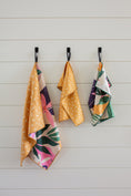 Load image into Gallery viewer, This last picture shows the 18"X30" Bamboo dishtowel hanging on a shiplap wall next to its matching 13"X13" washcloths.
